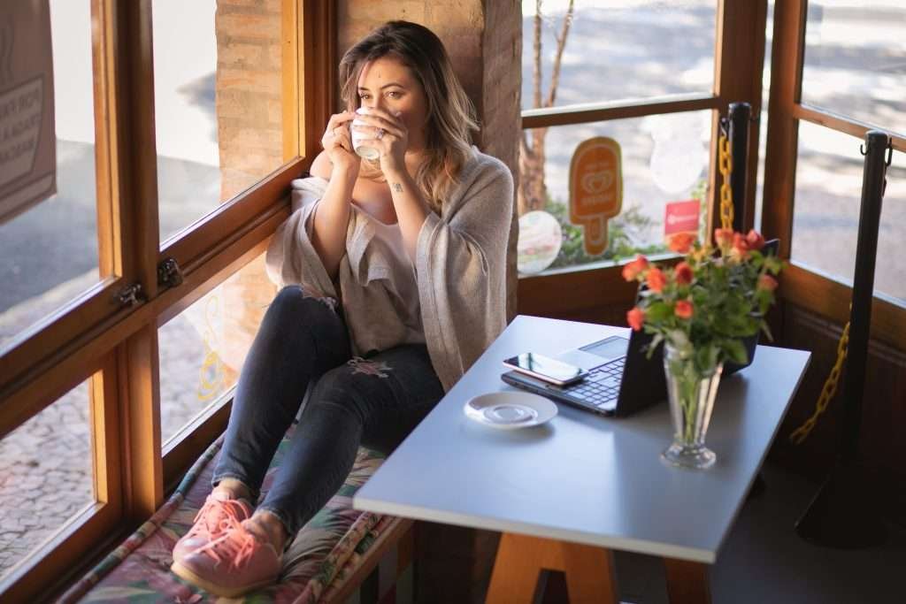 Ju sentado e tomando café pela janela
